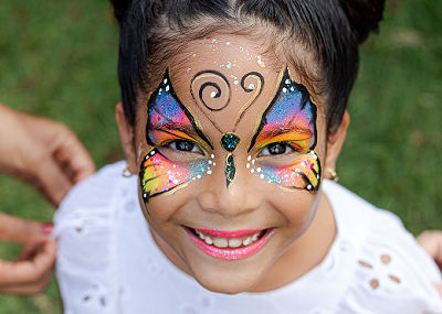 Criança Com Uma Cara Pintada Com Pinturas Coloridas Foto de Stock