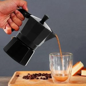 Cafeteira italiana preta enchendo copo com café.