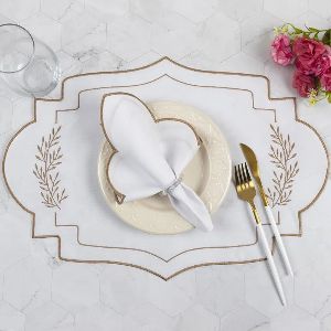 Mesa posta em tons claros com flor vermelha ao lado.