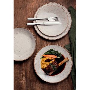 Mesa posta com pratos claros e comida servida em um deles.