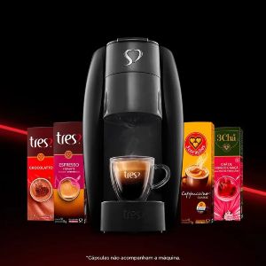 Foto de uma cafeteira expresso Três Corações com caixas de cápsulas dos lados.