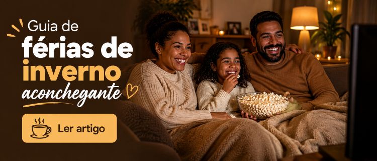 Família sentada no sofá de frente para a televisão assistindo à programação enquanto come pipoca.