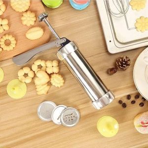 Mesa com biscoitos e utensílio para modelar massas de biscoito.