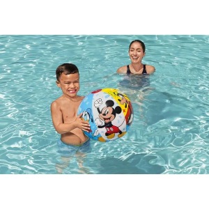 Menino e menina em piscina brincando com bola do Mickey.