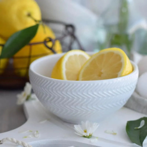 Bowl branco com limão siciliano cortado dentro.